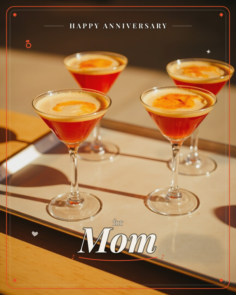 A photographic close-up shows four martini glasses filled with a deep red cocktail topped with pale golden foam and a curl of orange peel, arranged on…, a anniversary e-card design