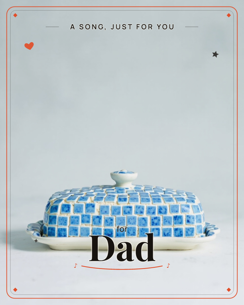 A ceramic butter dish sits centred against a soft grey-blue backdrop, its domed lid painted with a checkerboard of blue tiles edged in cream and topped…, a any occasion e-card design