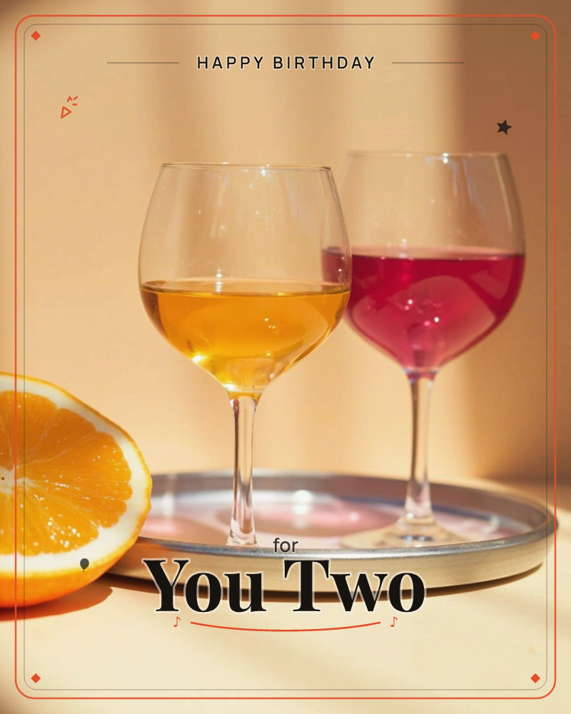 Two wine glasses sit on a round metal tray in warm sunlight, one holding amber wine and the other a deep magenta pour, with a halved orange in the…, a birthday e-card design