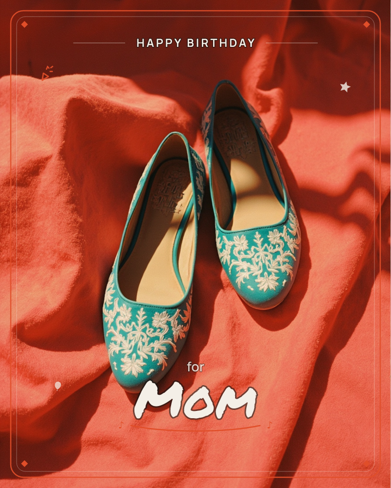 A pair of teal flat shoes embroidered with a white floral vine pattern rests on a rumpled coral-red fabric backdrop, a birthday e-card design