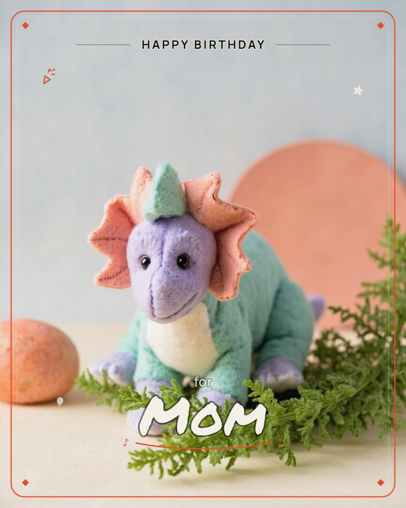 A plush triceratops toy in mint, lavender and coral sits on a cream tabletop, with a spray of feathery green foliage draped in front of it, a birthday e-card design