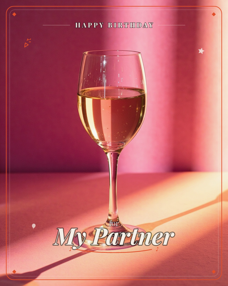 A single glass of white wine sits on a pink-toned surface, backlit by warm sunlight that streaks across the tabletop in bands of light and shadow, a birthday e-card design