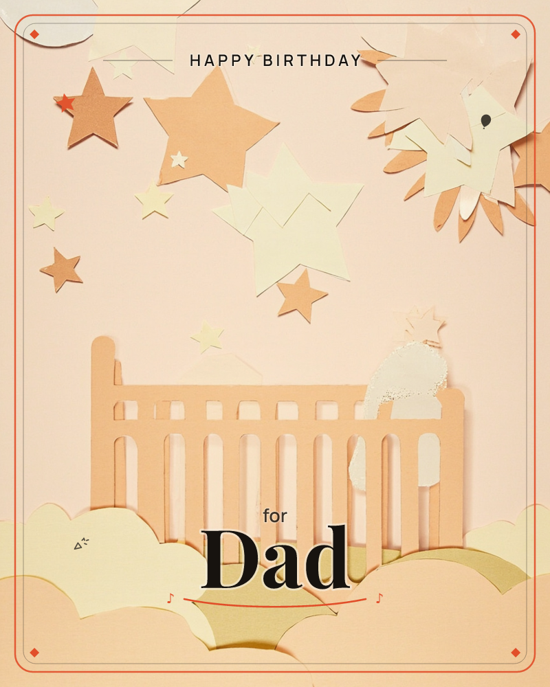 A paper-cut crib rail rises from soft cloud shapes against a peach sky scattered with layered cardboard stars and a burst of sunrays, a birthday e-card design