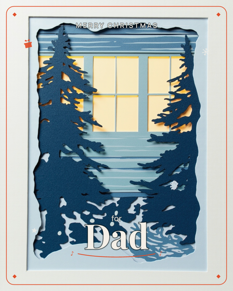 A layered paper-cut illustration shows two dark pine trees framing a cabin window glowing warm yellow against a snowy blue evening, a christmas e-card design