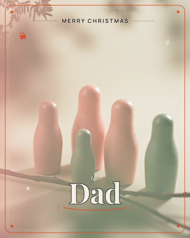 Five small ceramic figures, like rounded bottle-shaped nesting dolls, stand together on a bare branch against a softly blurred, hazy background, a christmas e-card design