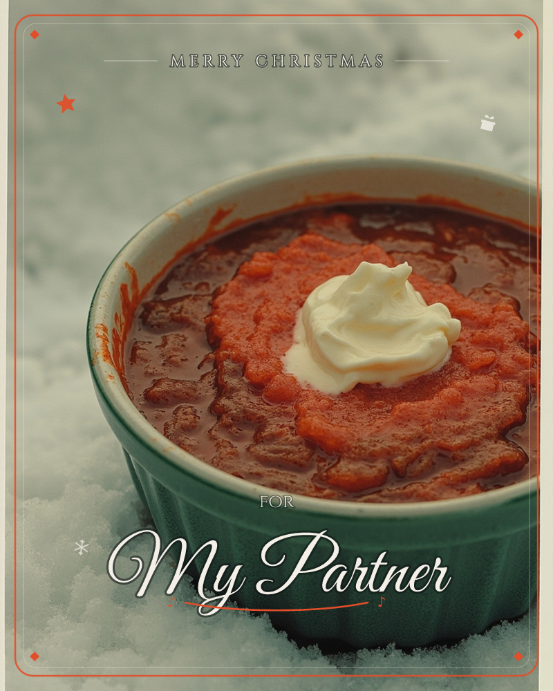 A ribbed green ceramic bowl sits nestled in fresh snow, filled with a hearty red chili topped with a swirl of sour cream, a christmas e-card design