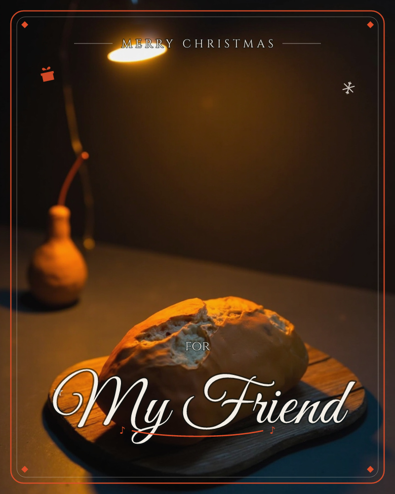 A single loaf of bread sits torn open on a dark wooden board, lit by a small overhead lamp that pools warm amber light across the table, a christmas e-card design