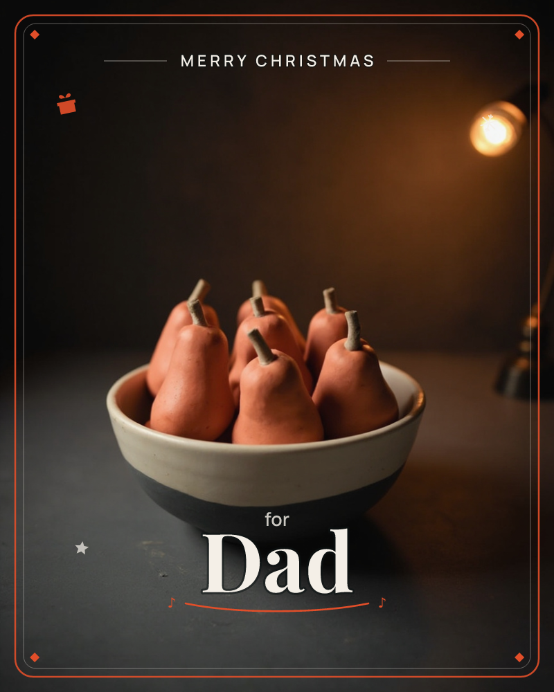A ceramic bowl, cream above and charcoal below, holds a cluster of pale coral-pink pears with their stems standing upright, a christmas e-card design