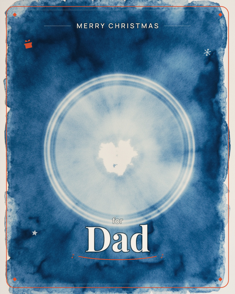 A deep indigo cyanotype print glows around a pale circular halo at its centre, ringed by two thin white lines like an eclipse, a christmas e-card design