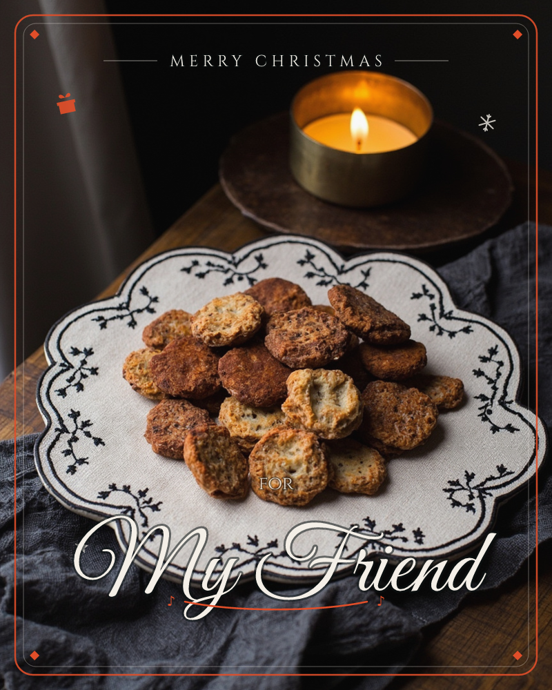 A pile of small round biscuits sits on a scalloped embroidered cloth, photographed on a dark wooden table with a lit candle glowing softly behind, a christmas e-card design