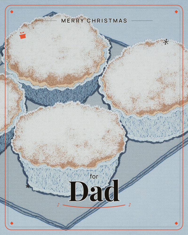 Four muffins with crackled, golden-domed tops sit crowded together on a slate-blue tray, rendered in a soft textured print like woven fabric, a christmas e-card design