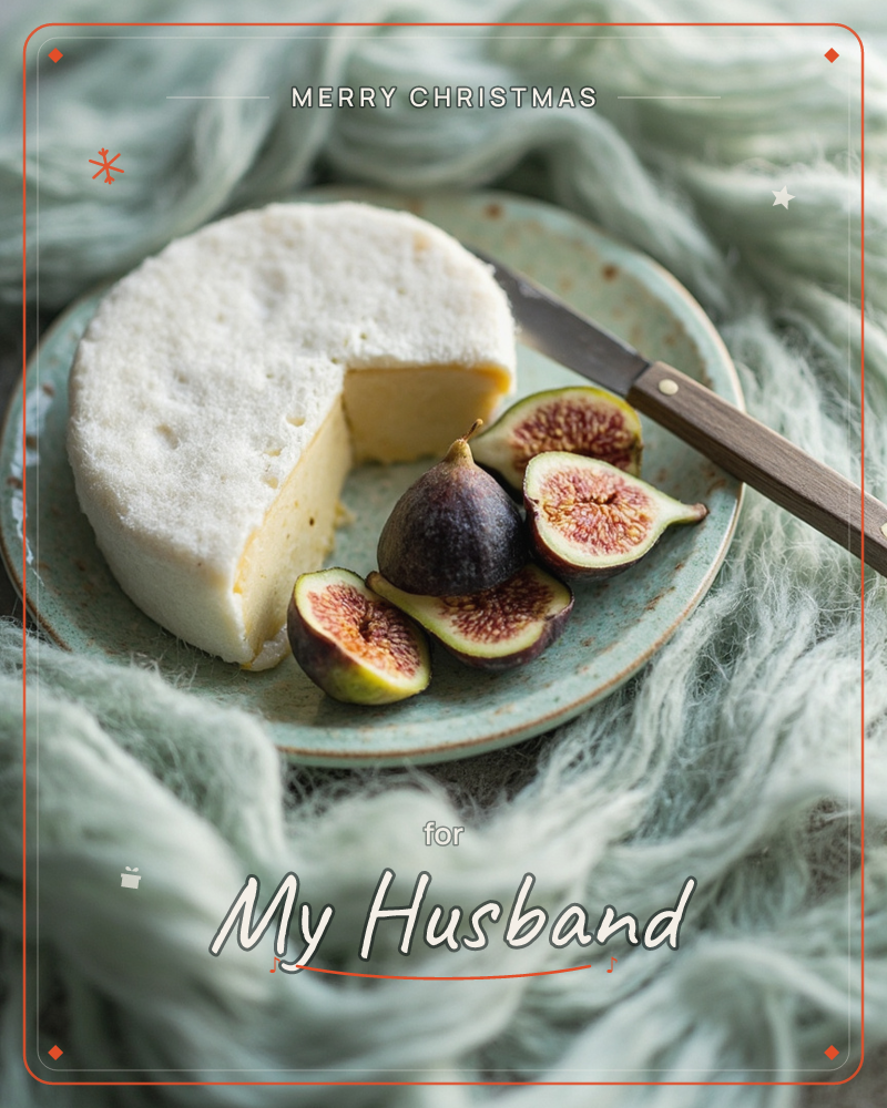 A round wheel of soft white cheese sits sliced open on a pale speckled plate, next to halved figs showing their deep pink centres and a dark-handled knife, a christmas e-card design