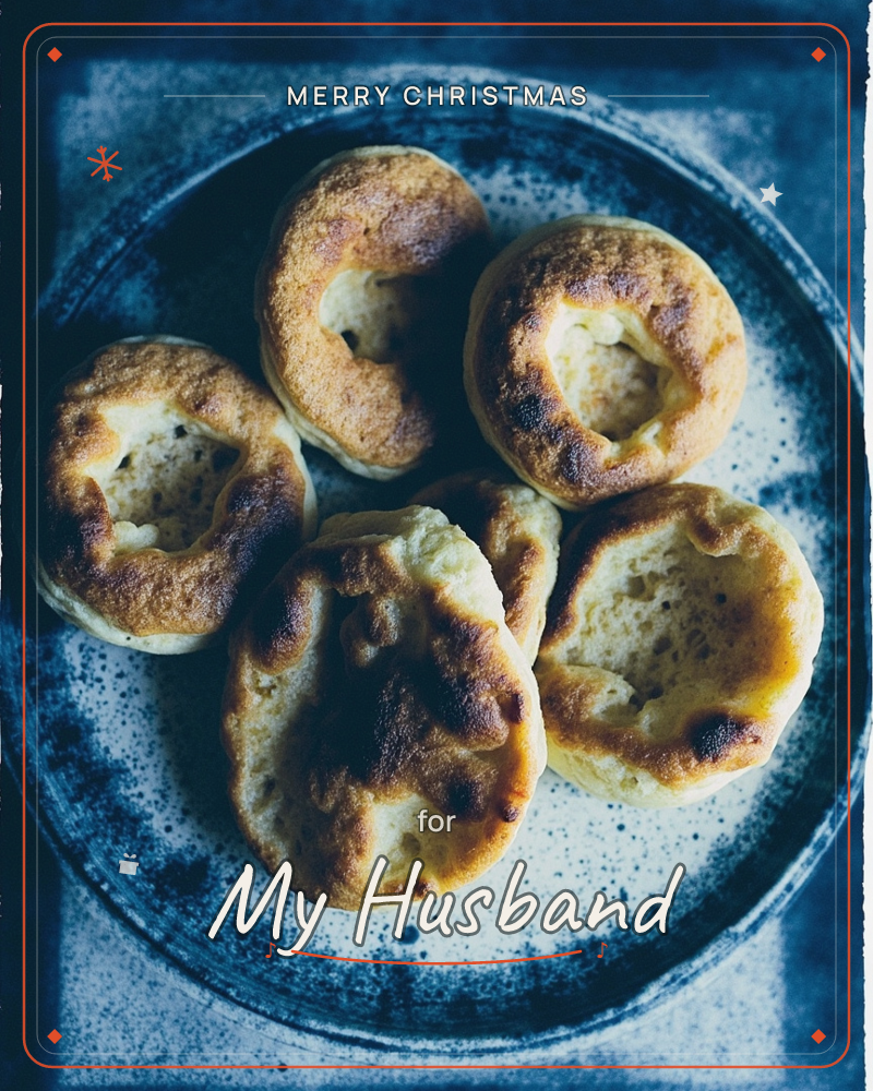 A speckled blue ceramic plate holds five golden bread rolls, each blistered and browned on top with a soft pale crumb showing through cracks, a christmas e-card design