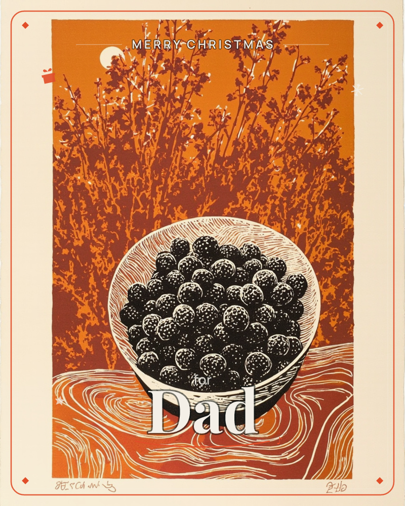 A linocut print shows a bowl heaped with dark blackberries set on a swirling wood-grain table, with a pale moon rising behind a tangle of bare branches, a christmas e-card design