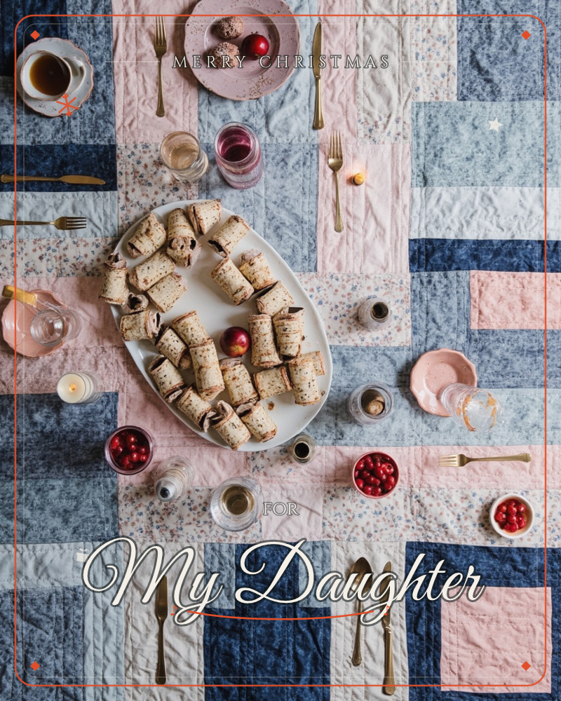 An overhead shot of a patchwork quilted tablecloth in navy, blush and cream squares, set for a gathering with gold cutlery, small glasses of wine and…, a christmas e-card design