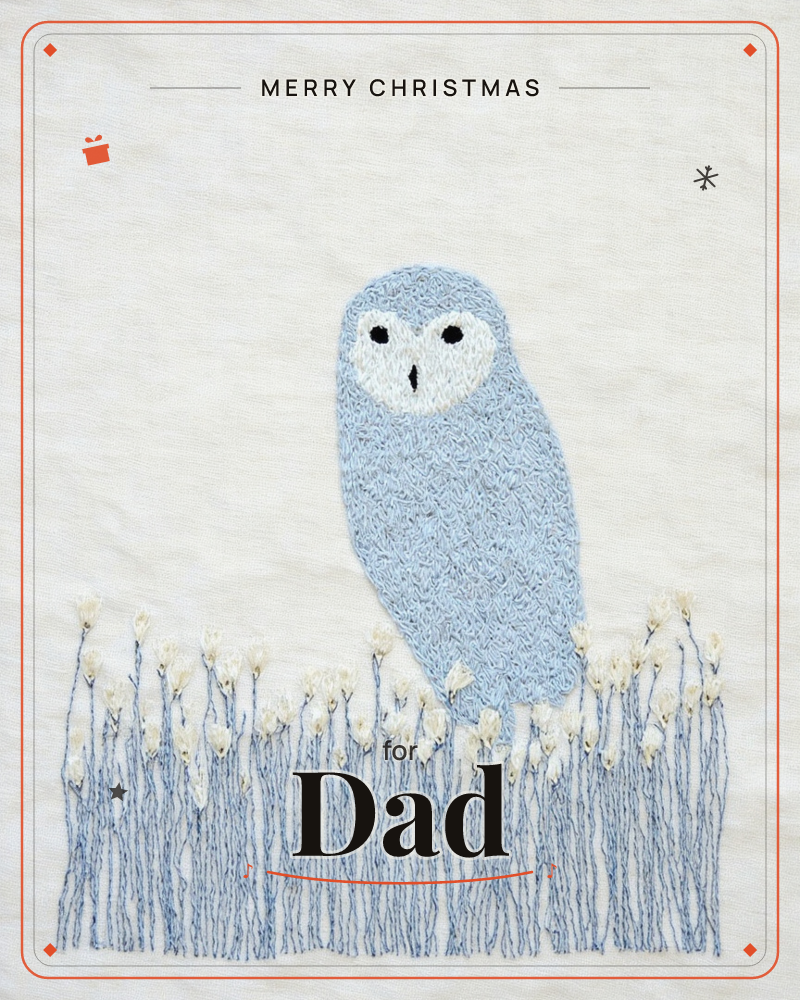 A pale blue owl with a round white face and dark eyes is embroidered standing among tall stitched grasses tipped with tiny cream flowers, a christmas e-card design