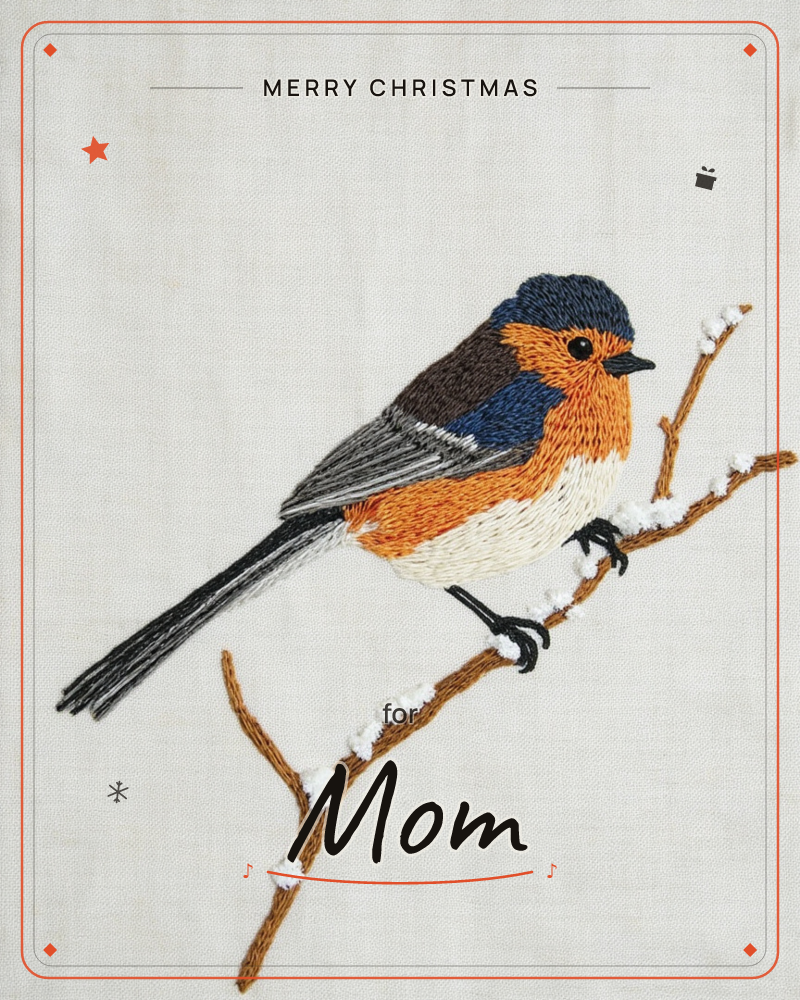 An embroidered songbird with a navy head, orange breast and grey-black tail perches on a bare twig dusted with little stitched clumps of snow, a christmas e-card design