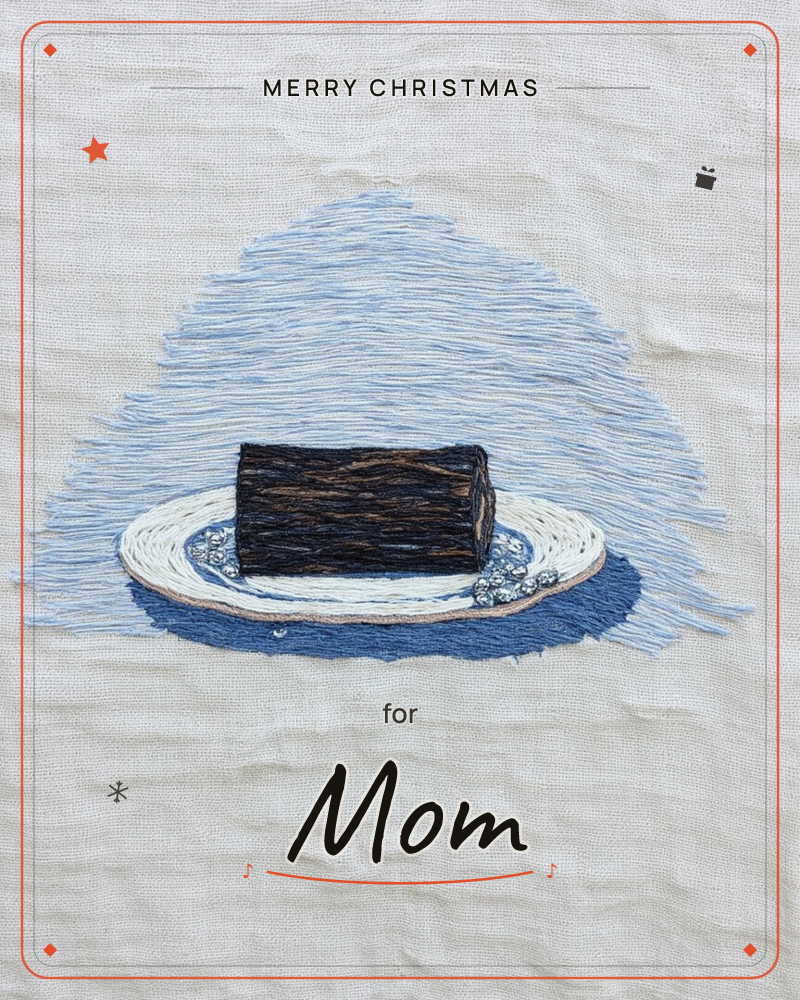 An embroidered chocolate log rests on a white plate against a pale blue thread-stitched glow, all worked onto raw linen fabric, a christmas e-card design