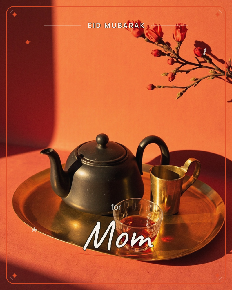 A black ceramic teapot sits on a brass tray beside a small glass of steeped tea and a brass cup, all bathed in warm terracotta light and sharp shadow, a eid e-card design