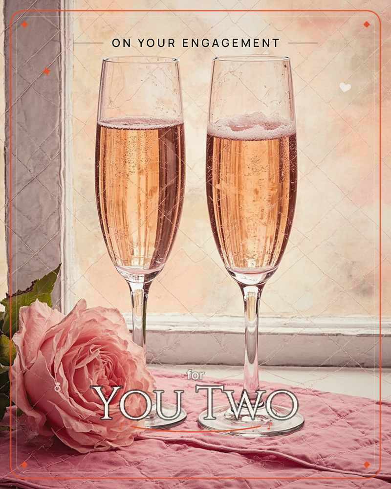 Two champagne flutes filled with pink bubbly stand side by side on a windowsill, catching the warm glow of soft golden light behind them, a engagement e-card design