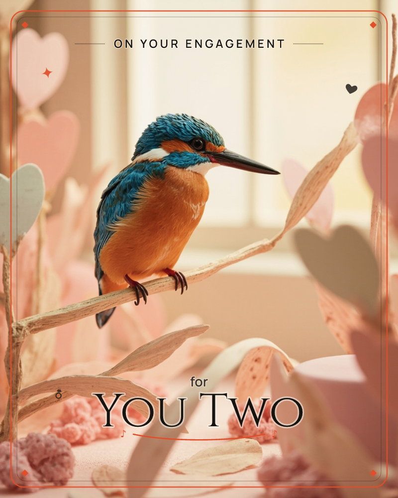A vivid blue and orange kingfisher perches on a pale branch inside a softly lit, dreamlike diorama scattered with paper hearts and blossoms, a engagement e-card design