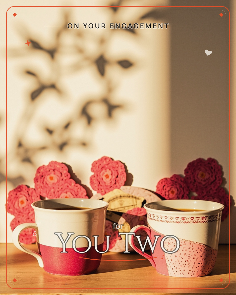 Two mugs of coffee sit side by side on a table, warmed by golden late-day light, with crocheted pink and red flowers piled softly behind them, a engagement e-card design