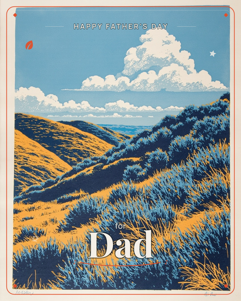 A print of golden hills studded with dark blue-green shrubs and wind-bent grasses, rolling down toward a distant sliver of sea, a fathersday e-card design