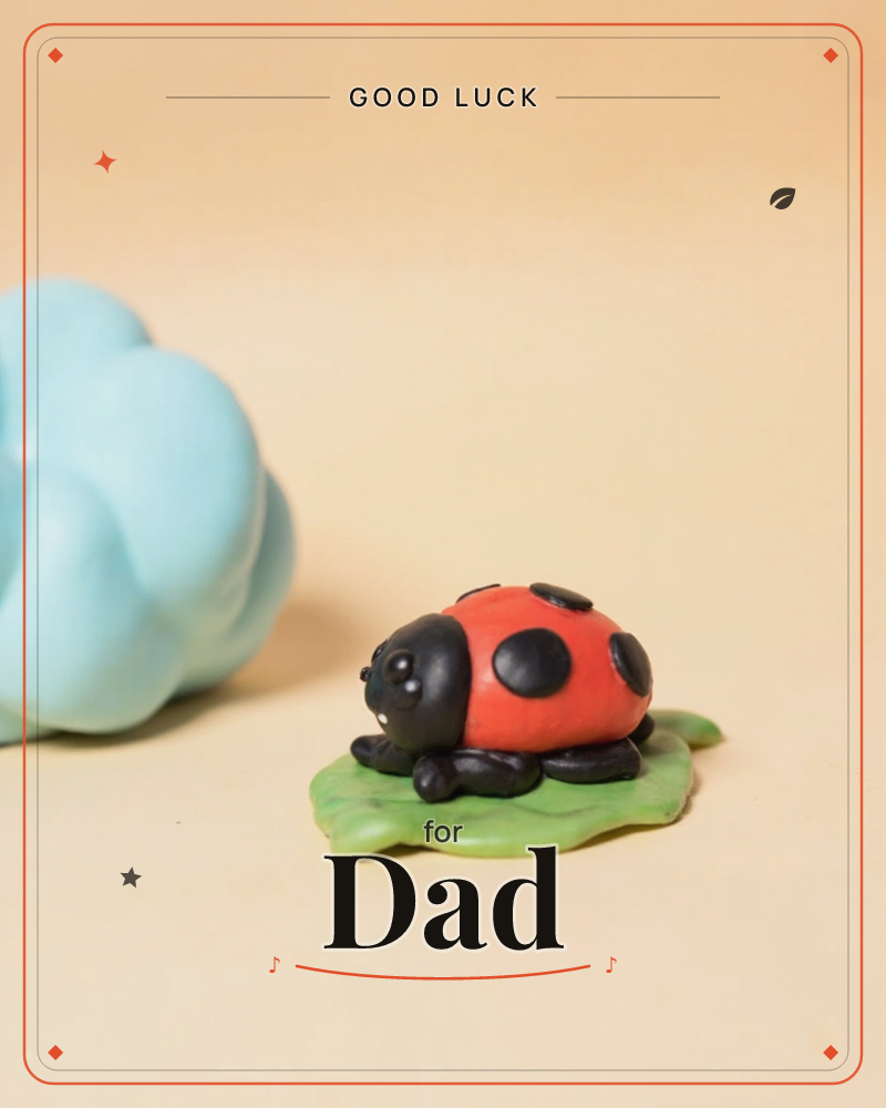 A tiny clay ladybird with glossy black spots perches on a green clay leaf, a soft pale-blue clay cloud floating beside it on a cream backdrop, a good luck e-card design