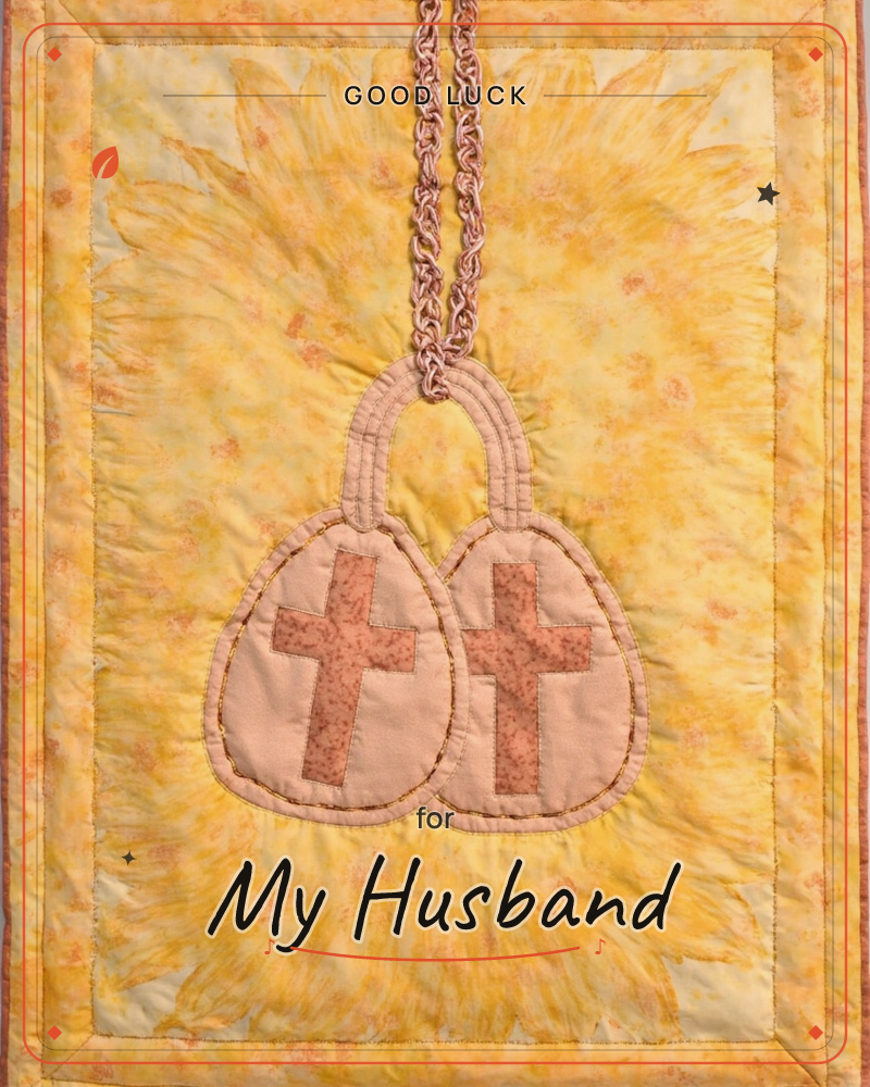 A quilted textile piece in warm golden-yellow batik fabric shows two egg-shaped pockets appliquéd side by side, each stitched with a small cross in…, a good luck e-card design