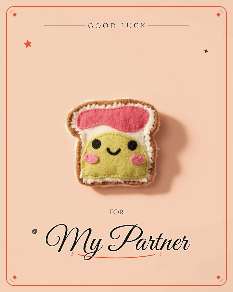 A plush felt toy shaped like a slice of peanut butter and jelly toast sits centered on a soft peach background, a good luck e-card design