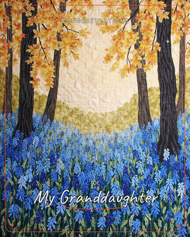 A quilted textile scene shows dark tree trunks rising through a carpet of blue bluebells, their canopies glowing gold against a pale quilted sky, a graduation e-card design