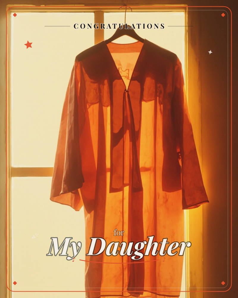 A graduation gown hangs on a wooden hanger against a sunlit window, its fabric glowing amber and rust where the light passes through, a graduation e-card design