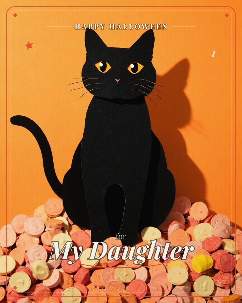 A paper-cut black cat sits bolt upright on a heap of pastel candy discs, its long tail curling around its front paws, a halloween e-card design
