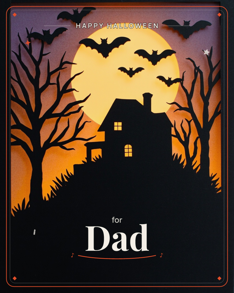 A layered paper-cut scene shows a silhouetted haunted house perched atop a hill, its windows glowing amber against a huge pale moon, a halloween e-card design