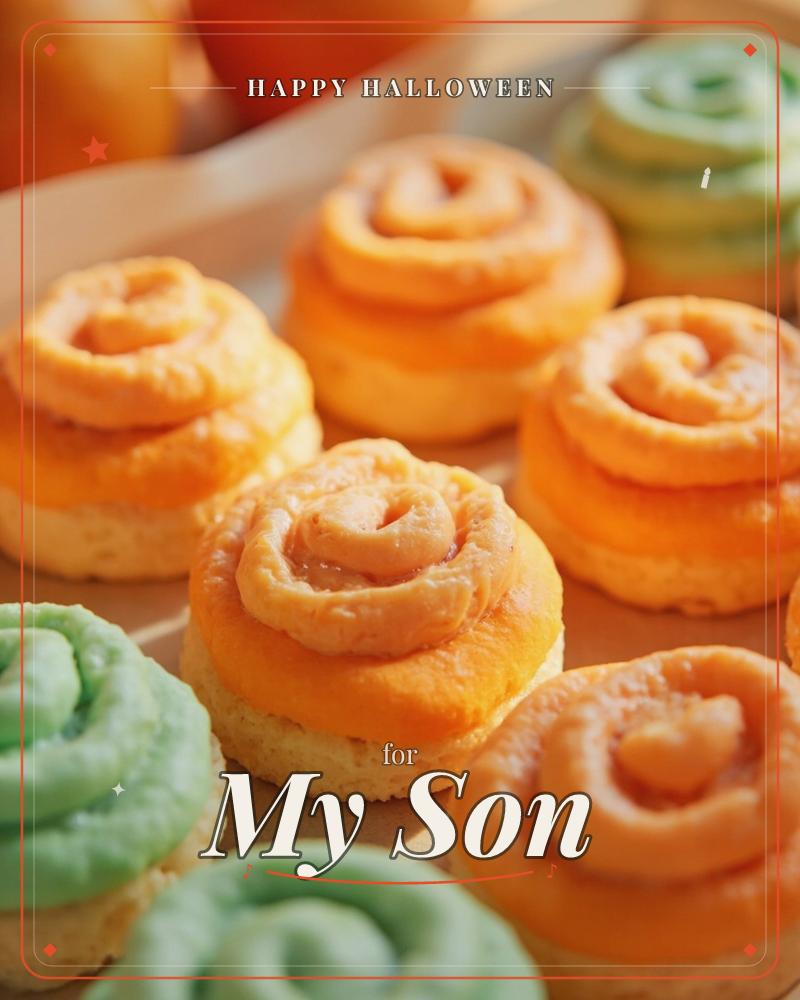 A close-up tray of frosted swirl cupcakes, most piped with bright orange icing and a few in soft mint green, catches warm afternoon light on a…, a halloween e-card design