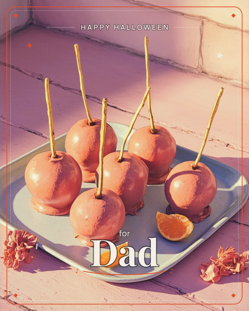 A tray holds six toffee-dipped apples, their glossy chocolate-pink shells catching warm sunlight, each stuck through with a slender wooden stick, a halloween e-card design