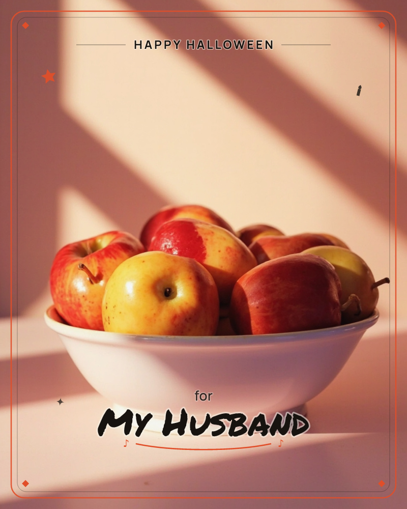 A white ceramic bowl piled with red and yellow apples sits on a pale pink surface, caught in a slant of late afternoon sun, a halloween e-card design