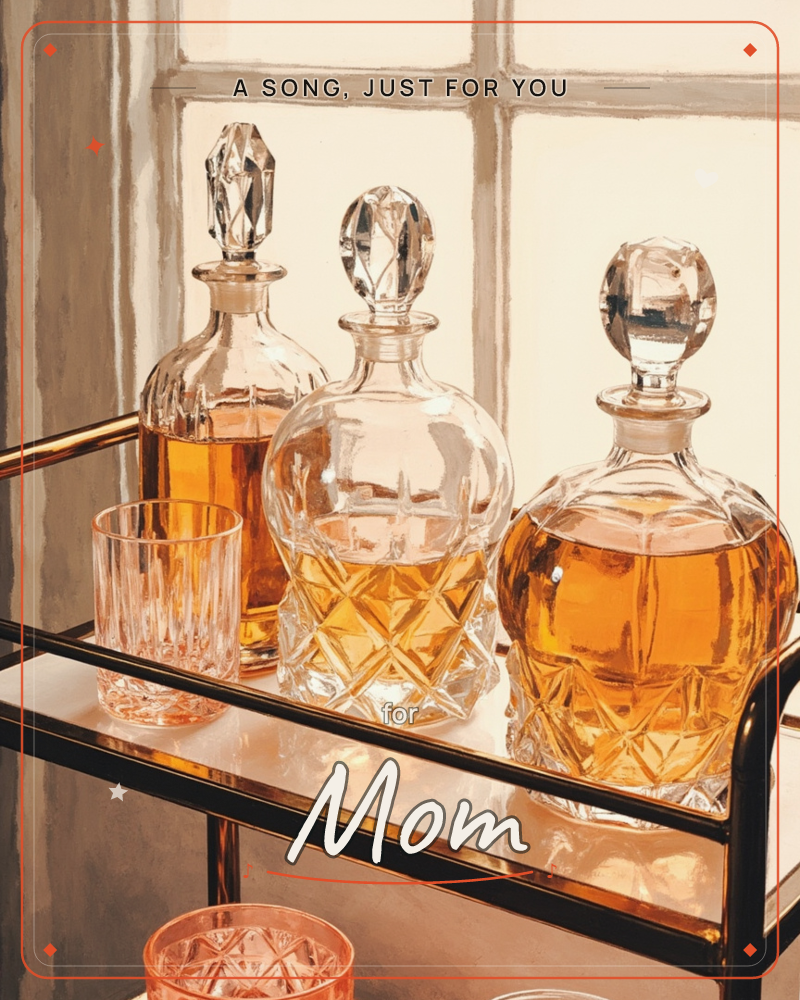 Three cut-crystal decanters filled with amber spirits stand on a mirrored bar cart beside a sunlit window, their glass stoppers catching the light, a just because e-card design