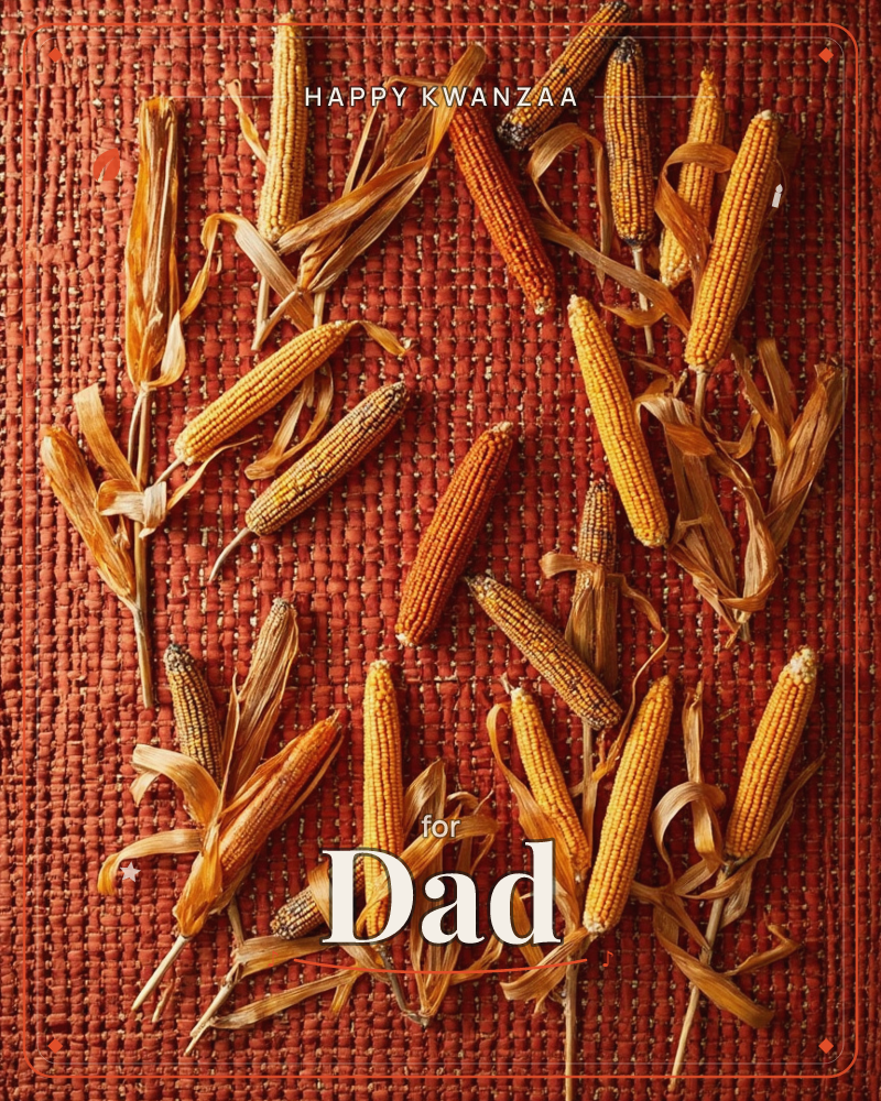 Dried ears of corn are scattered across a coarsely woven rust-red cloth, their husks curled back and papery, a kwanzaa e-card design