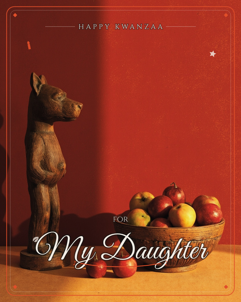 A carved wooden dog figure stands upright on a table beside a rustic wooden bowl heaped with apples, two loose apples resting on the surface nearby, a kwanzaa e-card design