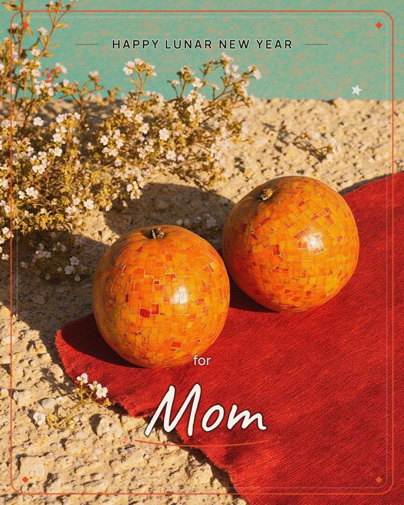Two orange orbs covered in a mosaic of tiny tiled fragments sit on a stone ledge beside a swatch of rust-red fabric, with a spray of small white baby's…, a lunar new year e-card design