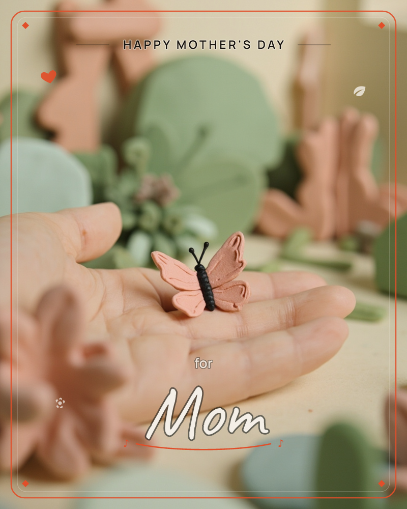 A hand rests open, cradling a tiny clay butterfly with soft pink wings and a black beaded body, a mothersday e-card design
