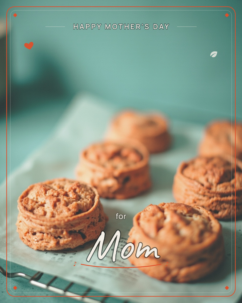 A close-up photograph of freshly baked round pastries or biscuits, their tops flecked and golden-brown, resting on baking paper printed with faint text, a mothersday e-card design