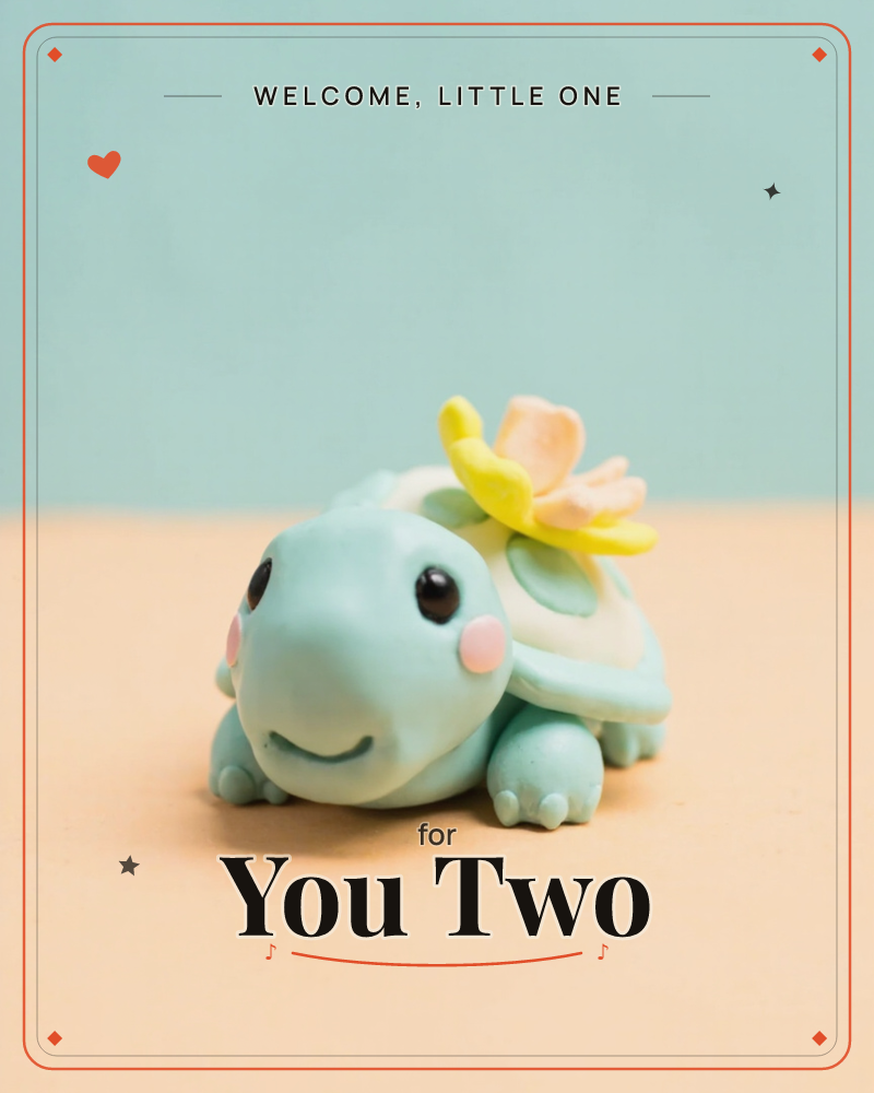 A small clay turtle figurine sits smiling on a plain tan surface, its pale mint shell topped with a soft yellow and peach flower, a new baby e-card design