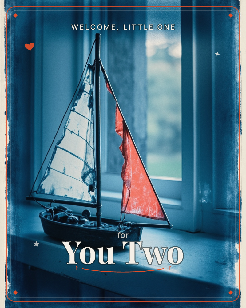 A small model sailboat with white and red canvas sails sits on a windowsill, backlit by a pale window and blurred greenery outside, a new baby e-card design