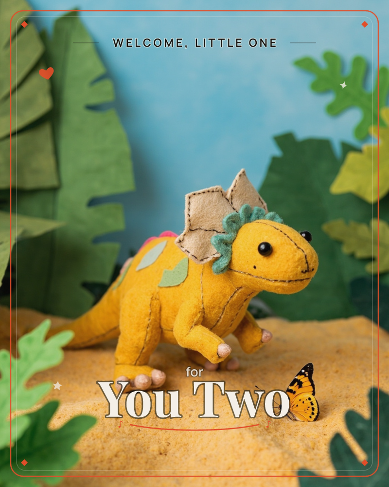 A handmade felt stegosaurus in mustard yellow stands on a sandy mound, its stitched spine plates edged in teal and pink, meeting a small orange…, a new baby e-card design