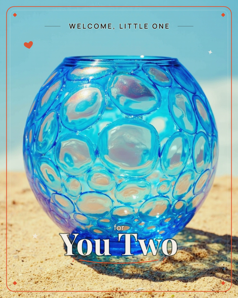 A round blue glass vase, its surface covered in bubble-like raised circles, sits in bright sand under a clear sky, a new baby e-card design
