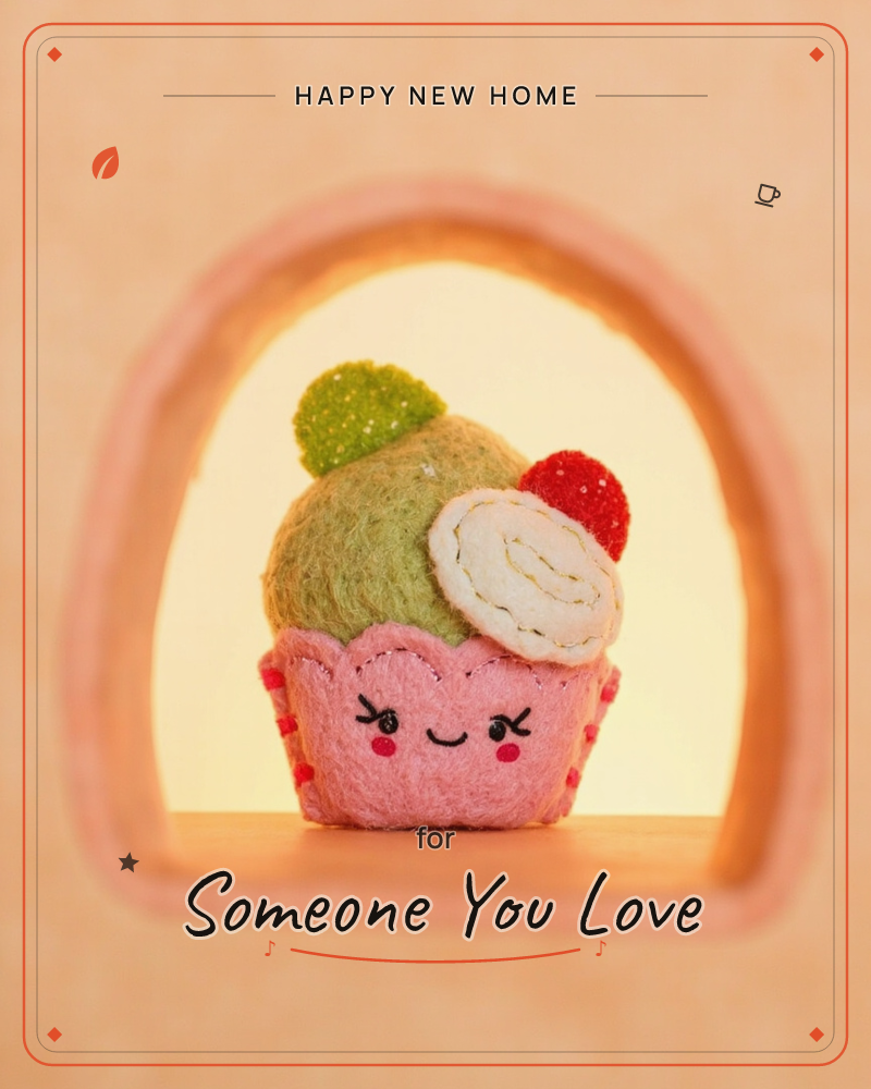 A felt cupcake character with a smiling stitched face sits inside a rounded peach archway, its green felt frosting topped with a red berry and a…, a new home e-card design