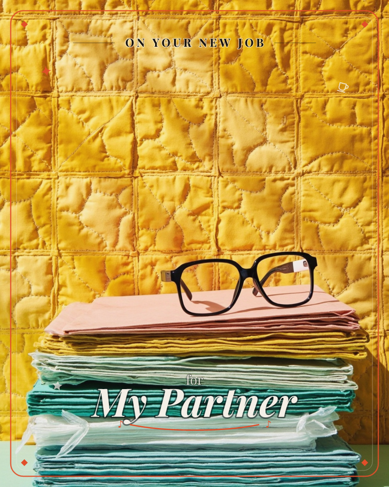 A pair of black-framed glasses rests on top of a neatly folded stack of pastel fabrics, set against a quilted golden-yellow backdrop, a new job e-card design