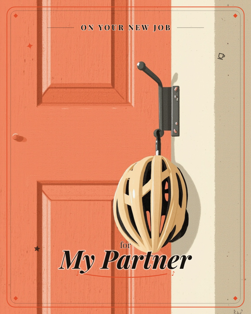 A cream-colored bicycle helmet hangs from a black metal hook mounted beside a coral-orange paneled door, a new job e-card design